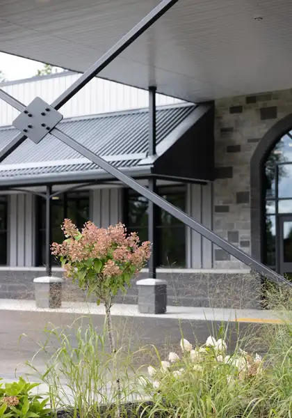 Front entrance of Legacy Events with stone walls, arched windows, and garden plantings