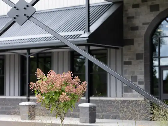 Front entrance of Legacy Events with stone walls, arched windows, and garden plantings
