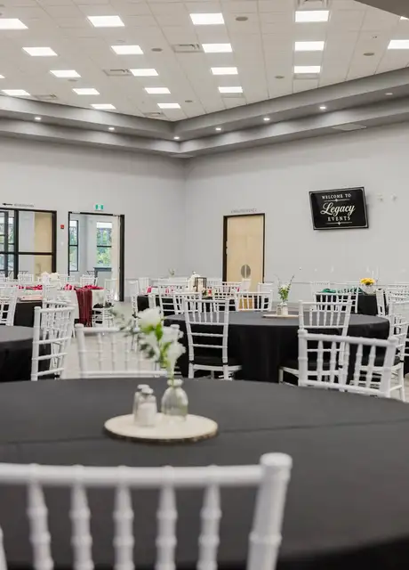 Ballroom at Legacy Events set with round tables and white chairs for a formal event