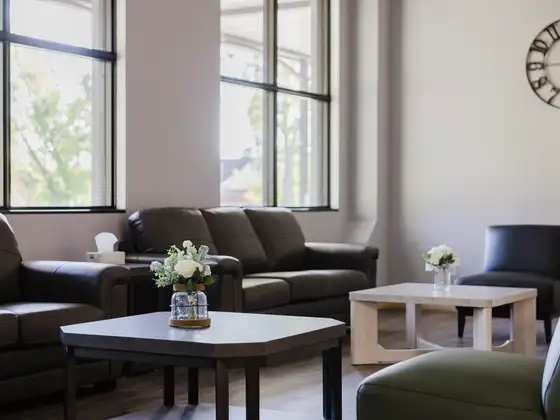 Lounge with leather sofas and coffee tables beside tall windows