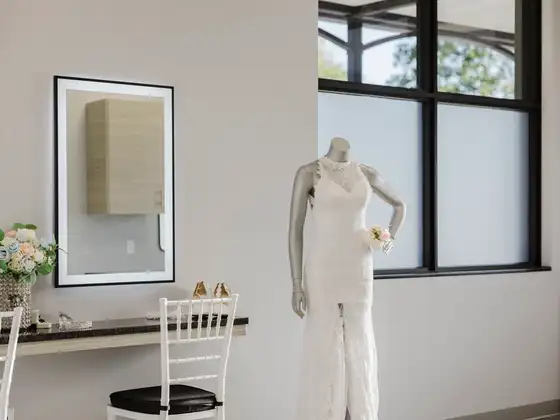 Bridal suite with a lit vanity mirror and a wedding dress on display