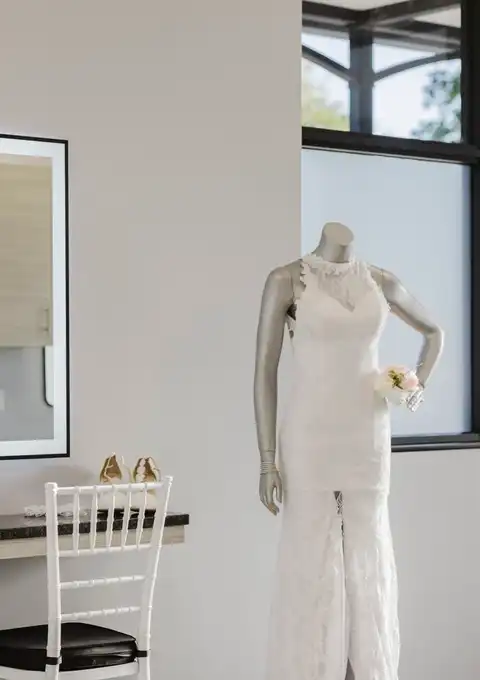 Bridal suite with a lit vanity mirror and a wedding dress on display