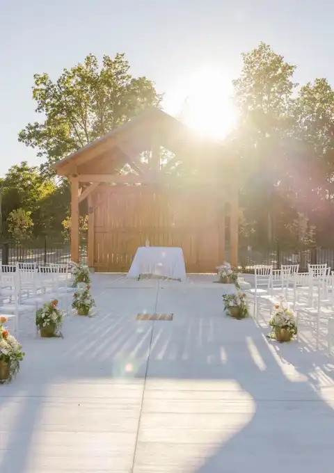 Rows of white chairs facing the timber ceremony pavilion on the outdoor patio