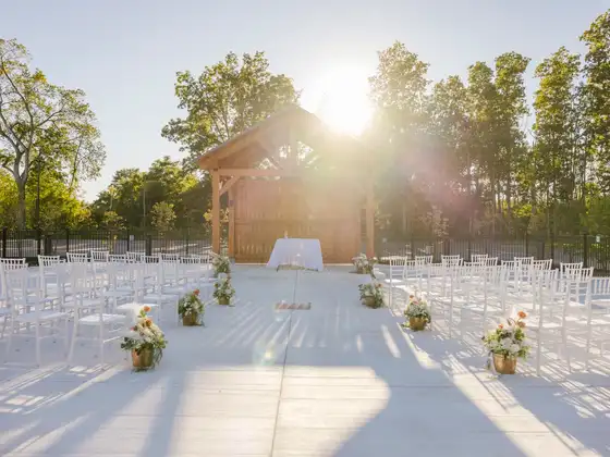 Rows of white chairs facing the timber ceremony pavilion on the outdoor patio