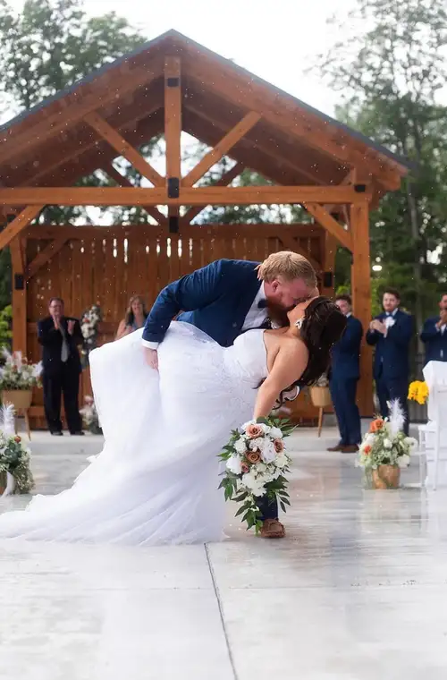 Couple sharing a kiss in front of the timber ceremony pavilion at Legacy Events in Belleville
