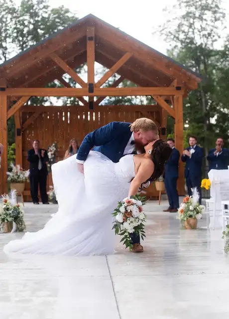 Couple sharing a kiss in front of the timber ceremony pavilion at Legacy Events in Belleville